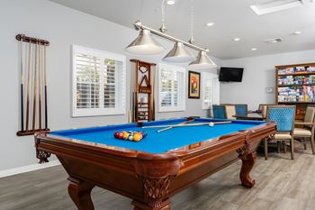 A pool table with a blue cloth and a few balls on it.